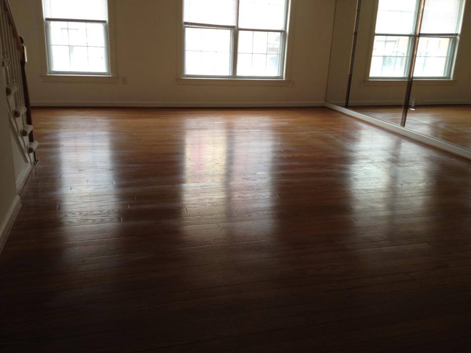 Hardwood floors cleaned and buffed to a shine in a bright empty room
